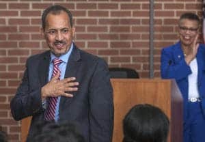 Man giving a speech at a professional event, engaging with the audience, with a smiling woman in the.