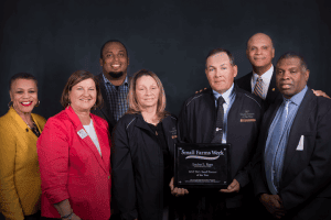 Group of CAES leaders and farmers celebrating Small Farms Week, holding an award plaque.