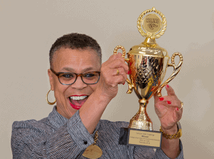 An inspiring woman holding a gold trophy, celebrating success and victory.