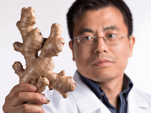 Man holding fresh ginger root, promoting natural health remedies.