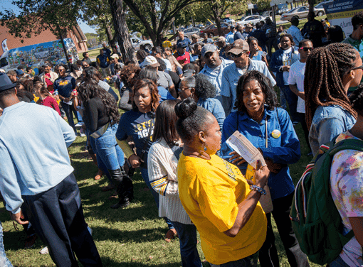 Community gathering at outdoor event in a park.