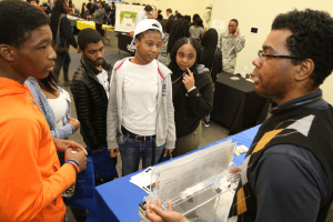 Students engaging with a STEM demonstration at a science fair.
