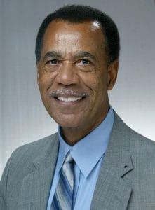 Confident businessman in a gray suit smiling at the camera.