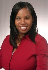 Professional woman smiling in red blazer, representing CAES News, showcasing confidence and professi.