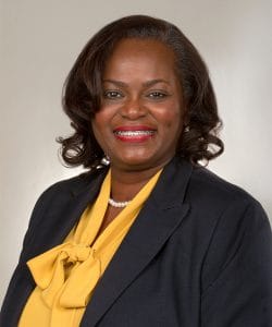 Empowered African American woman in professional attire smiling confidently for business or news pro.