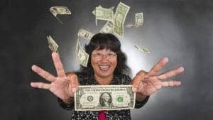 A woman smiling and holding a dollar bill with money flying around her.