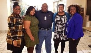 Group of diverse professionals smiling together in an office setting.