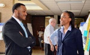 A woman and a man engaging in conversation at a professional event or conference.