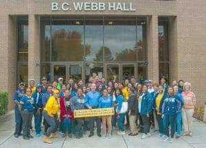 Community group photo outside B.C. Webb Hall at college campus, showcasing students and staff in vib.