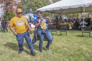Enjoying outdoor community event with dancing and socializing under a tent.