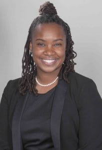 Elegant African American woman smiling in professional attire, representing leadership and confidenc.