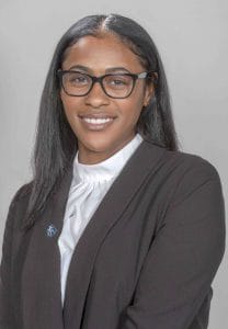 Empowered professional woman in business attire smiling confidently for corporate headshot.