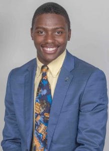 A smiling young African American man in a blue suit and colorful tie for professional business appea.