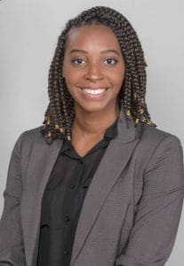 A woman in professional attire smiling for a business portrait.