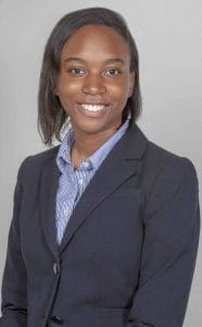 A woman in professional business attire smiling for a corporate portrait.