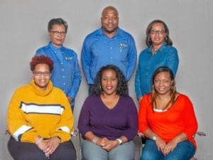 Empowered diverse team of professionals posing together for a group photo at CAES News.