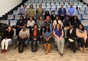 Group of diverse professionals and students in a lecture hall at CAES News event.
