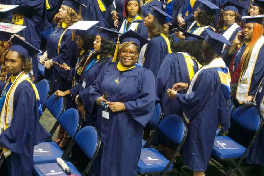 Graduates in caps and gowns at a university graduation ceremony, celebrating academic achievement an.