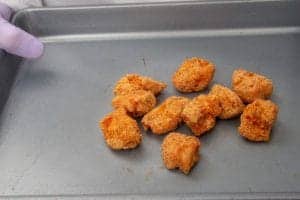 Fried chicken nuggets on a metal tray, ready for serving or cooking.