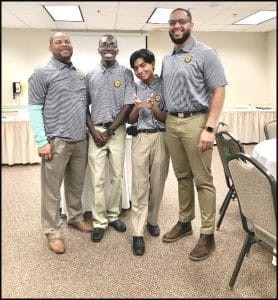 Diverse group of young professionals in matching striped shirts at a conference or seminar.