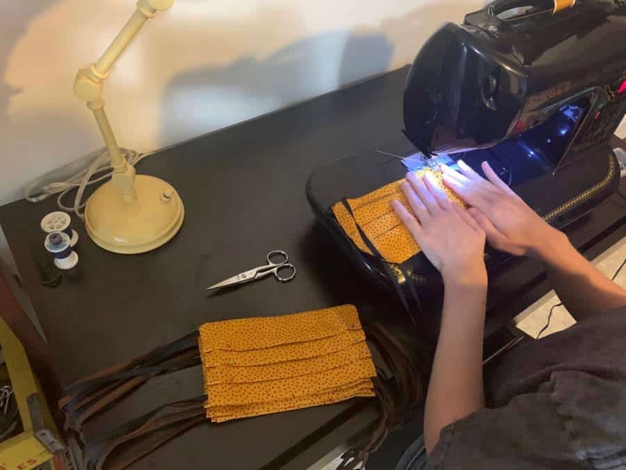 Sewing machine with fabric and tools on a workspace for textile production.
