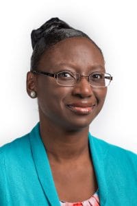 Professional woman wearing glasses and a blue blazer, representing leadership and expertise in CAES.