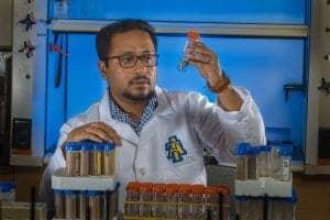 A scientist conducting a chemistry experiment in a laboratory with test tubes and lab equipment.