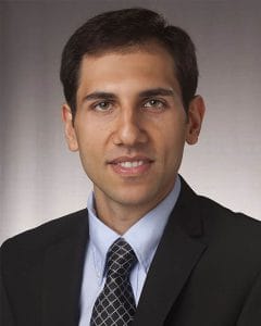 Business professional in suit and tie with a friendly expression.