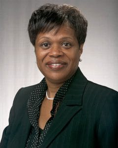Confident African American woman in business suit, smiling, for CAES News article.