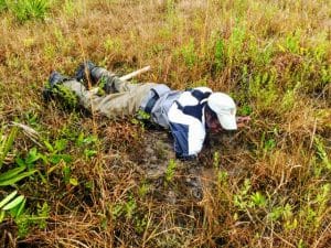 Rescuer in outdoor wetland area searching for missing person.
