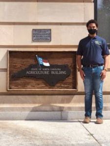 Person standing outside South Carolina Agriculture Building with face mask.