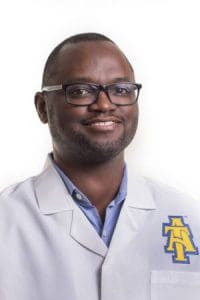 A professional male doctor wearing glasses and a white lab coat with CAES logo.