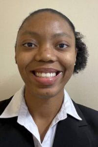Portrait of Lauren Arnao wearing a black blazer and white collared shirt, smiling