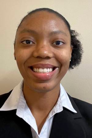 Portrait of Lauren Arnao wearing a black blazer and white collared shirt, smiling