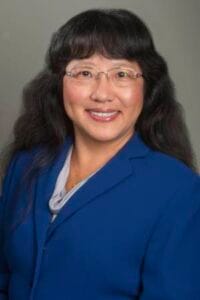 A woman in a blue blazer smiling, professional portrait for CAES News.
