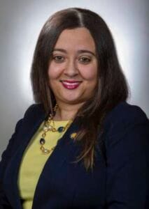 A woman in professional attire smiling, representing CAES News and media coverage.