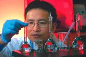 A scientist conducting chemical experiments in a laboratory with glassware and lab equipment.