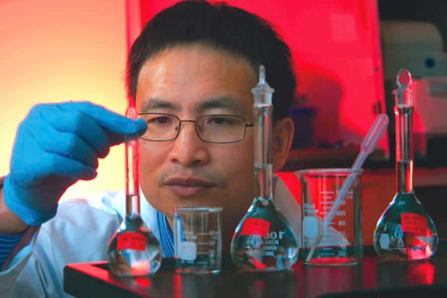 A scientist conducting chemical experiments in a laboratory with glassware and lab equipment.