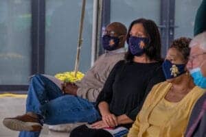 COVID-19 safety measures: diverse group of people wearing face masks at a public event.