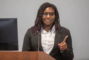 Empowered woman speaker at conference delivering presentation on leadership and innovation.