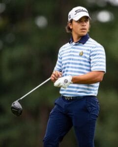 A young female golfer preparing to swing on a golf course.