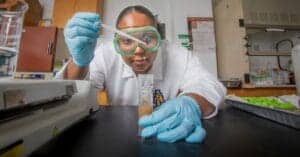 A scientist conducting a laboratory experiment with test tubes and scientific equipment.