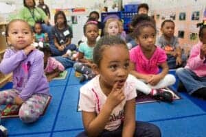 Learning children attentively listening in classroom setting.