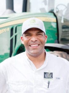 Agricultural professional smiling in front of tractor at CAES News event.