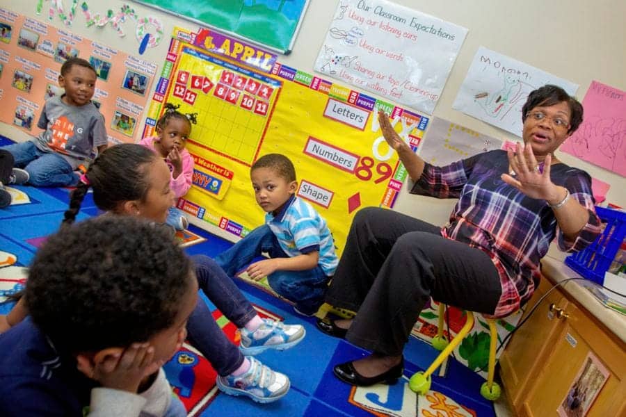 Engaging classroom scene with teacher and young students participating in learning activities.