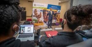 Business presentation at conference with speaker and audience in a modern setting.