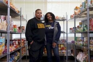 Aisles of grocery store with two smiling customers shopping together.