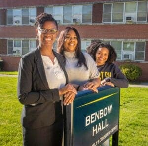 A woman and two young women standing outdoors next to a sign that reads "Benbow Hall" at CAES News.