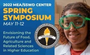 Young girl wearing safety goggles at agricultural science event, smiling.