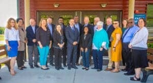 Diverse group of professionals standing outside a building, smiling for a team photo at CAES News ev.
